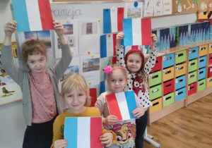Dzieci prezentują wykonane flagi Francji.